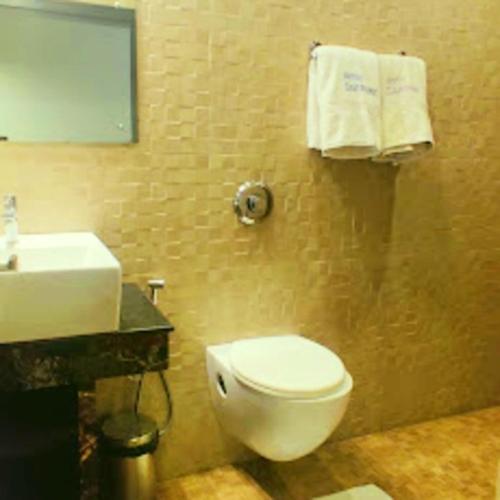 a bathroom with a white toilet and a sink at Majestic Mano in Shillong