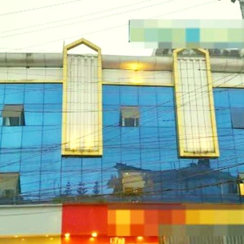 a reflection of a blue building with windows at Majestic Mano in Shillong