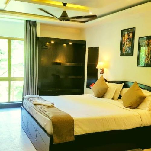 a bedroom with a large bed with a ceiling fan at Majestic Mano in Shillong