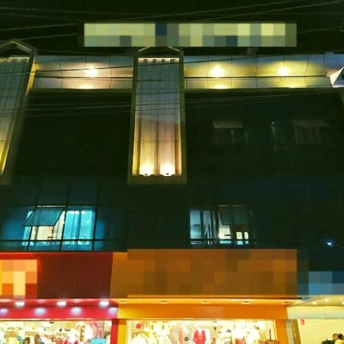 a tall building with lights on in front of it at Majestic Mano in Shillong