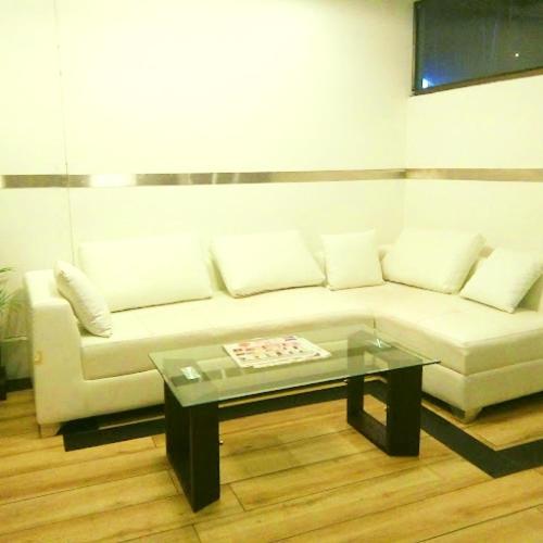 a living room with a white couch and a glass table at Majestic Mano in Shillong