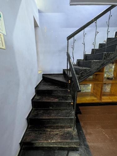 a set of stairs in a building with a railing at Hill View cottage in Khandala