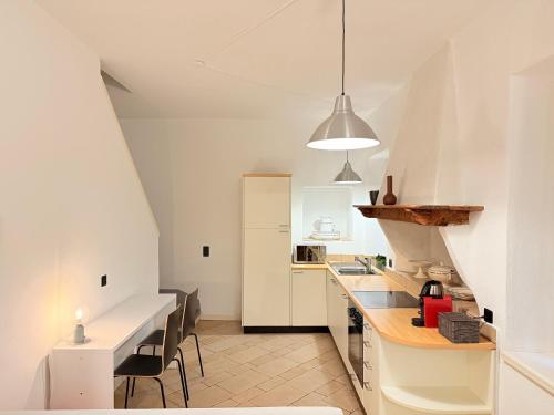 a kitchen with white cabinets and a table and chairs at Gritti Palace Morcote - Camelia - Spacious historic house by the lake in Morcote