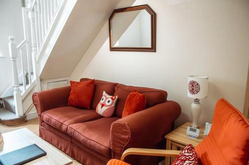 a living room with a brown leather couch with pillows at Spacious Holiday Home with Free Parking in Harrogate