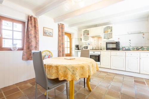 a kitchen with a table with a yellow table cloth at Gîte Ty Bihan in Rosporden