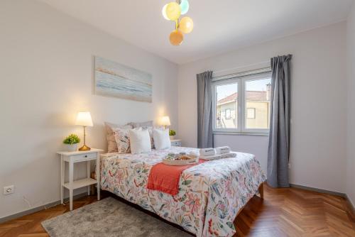 a bedroom with a bed and a window at HostWise - Bright & Spacious Flat w/ Garage in Porto