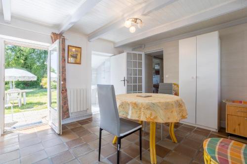 a dining room with a table and chairs and a patio at Gîte Ty Bihan in Rosporden