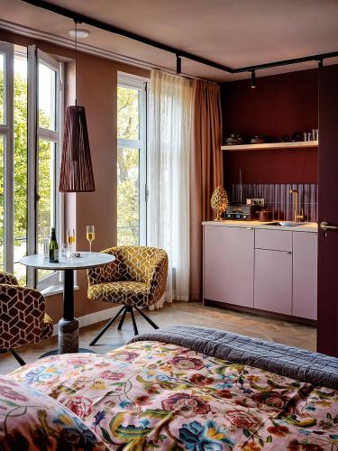 a bedroom with a bed and a table and a kitchen at Suites aan de Gracht Utrecht in Utrecht
