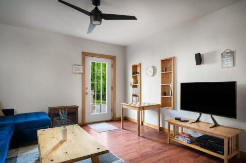 a living room with a flat screen tv and a blue couch at Cabin w New Hot Tub, River, Kayak, WiFi, & Fire Pit in Morton Grove
