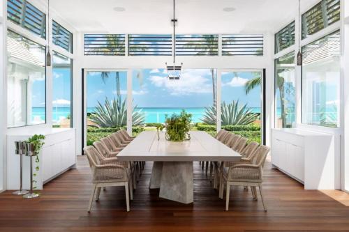 a dining room with a table and chairs and the ocean at Villa Azure Turks Caicos in Leeward