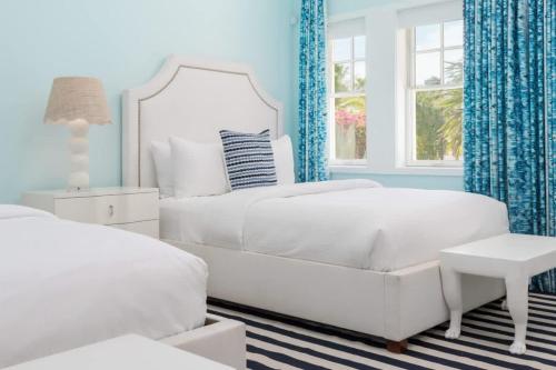 a white bedroom with a white bed and a chair at Villa Azure Turks Caicos in Leeward