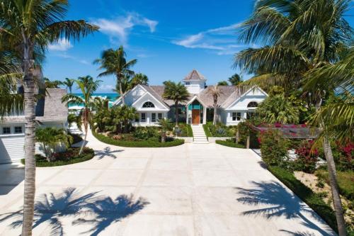 a house on the beach with palm trees at Villa Azure Turks Caicos in Leeward
