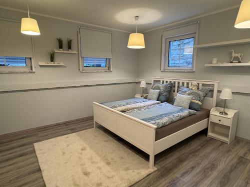 a bedroom with a bed and two windows at Ferienwohnung Landshut am Gambach in Hohenthann