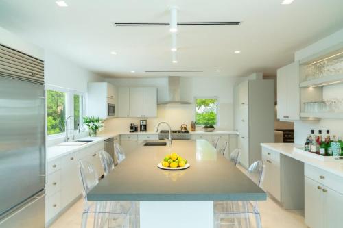 a kitchen with a table with a bowl of fruit on it at Villa Turquoise Turks Caicos in Leeward