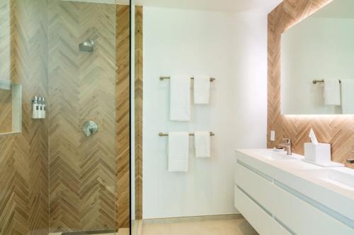 two images of a bathroom with a sink and a shower at Villa Turquoise Turks Caicos in Leeward
