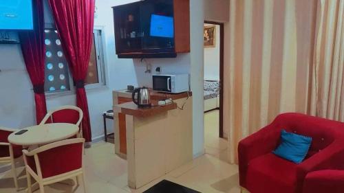 un soggiorno con divano rosso e sedia rossa di Résidence SKS Hébergement a Dakar