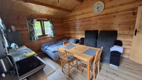 a living room with a table and a couch at Letniskowy Domek Berneński Zakątek in Charzykowy