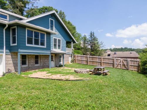 a yard with a blue house and a wooden fence at Stella Maris in Blowing Rock