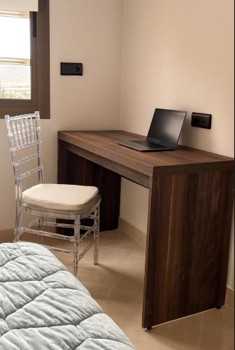 a desk with a laptop on it with a chair at Serenity apartments in Azrou