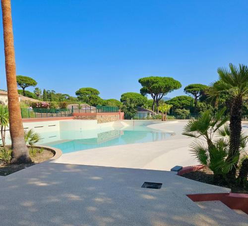 une piscine avec un skate park avec des palmiers dans l'établissement GASMIM18 - Golfe de St-Tropez - Maison climatisée dans domaine arboré, à Gassin