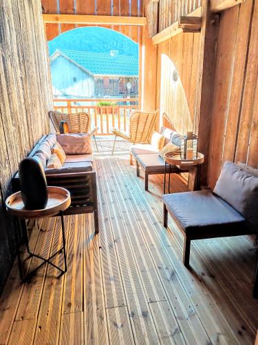 - un salon avec des canapés, des tables et une fenêtre dans l'établissement Chez Léon, Jacuzzi et sauna dès le 1er septembre 2025, à Samoëns