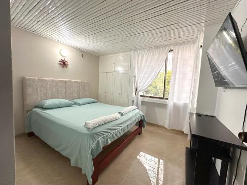 a bedroom with a bed and a flat screen tv at Casa completa con aire acondicionado , Excelente ubicacion in Valledupar