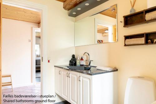 a kitchen with white cabinets and a sink at Akaciegaarden Bed & Breakfast in Hårlev