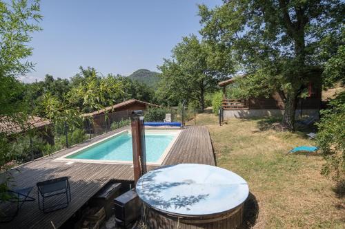 - une piscine avec une table à côté d'une maison dans l'établissement Chalet Bleu - Piscine Partagée, à Darbres