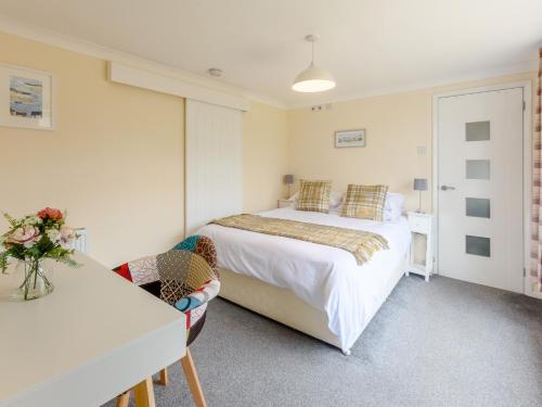 Un dormitorio con una cama, un escritorio y una mesa. en 3 Bed in Freshwater 79039, en Freshwater