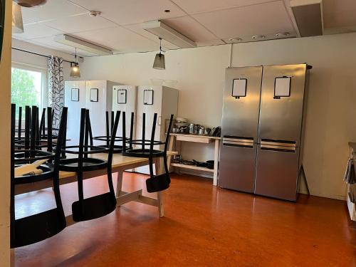 a room with a table and a stainless steel refrigerator at Rentalux Hostel - Budget Double & Single rooms in Timrå
