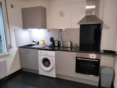 a kitchen with a washing machine with a dog in it at Maison rénovée aux bords de Loire in Imphy