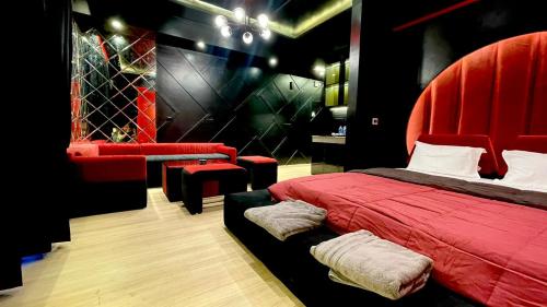 a bedroom with a red bed and a red chair at The Grace Residency - Premier , Gomtinagar , Lucknow in Lucknow