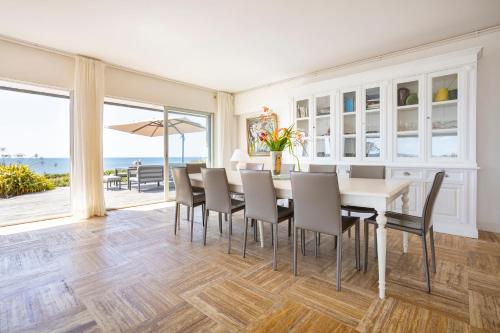 une salle à manger avec une table et des chaises et l'océan dans l'établissement Magnifique villa accès direct plage, à Audierne