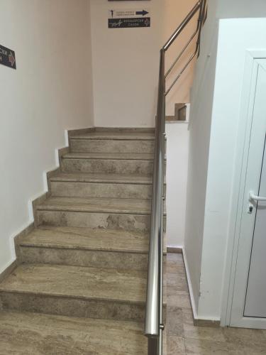 a staircase with a metal handrail and wooden floors at студио КОМФОРТ в центъра на град Сандански in Sandanski