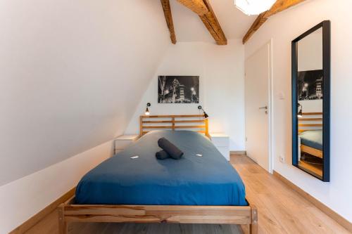 - une chambre mansardée avec un lit bleu dans l'établissement Colmar Historic Center - BELLE ALSACE 5 - 4 étoiles, à Colmar