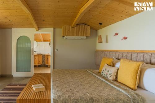 a bedroom with a bed and a wooden ceiling at StayVista at The Ever House with Bonfire, Jacuzzi, Bathtub in Dharampur