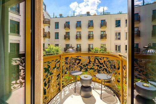 a balcony with tables and chairs and a building at Kimpton BEM Budapest by IHG in Budapest