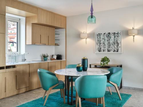 a kitchen and dining room with a table and chairs at The Chedi Luštica Bay in Tivat