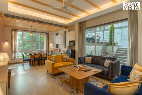 a living room with a couch and a table at StayVista at The Ever House with Bonfire, Jacuzzi, Bathtub in Dharampur