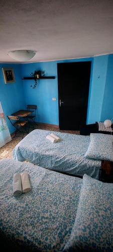 two beds in a room with blue walls at La Dimora di Beatrice in Santa Brigida