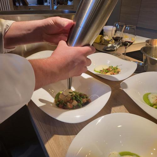 a chef preparing a plate of food on a table at Château de Courtebotte in Saint-Jean-de-Blaignac