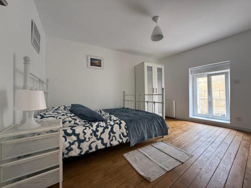 エルマンヴィル・シュル・メールにあるMaison de charme sur la côteのベッドとドレッサーと窓のある寝室