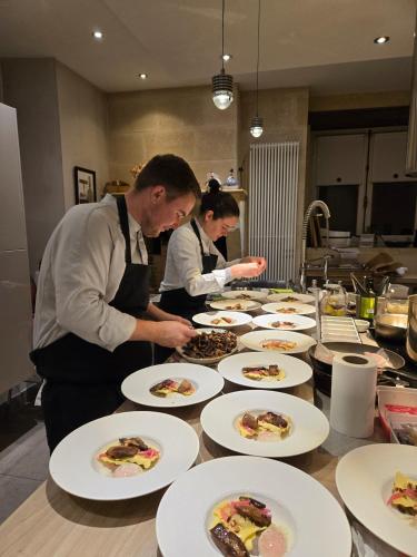 two chefs in a kitchen preparing plates of food at Château de Courtebotte in Saint-Jean-de-Blaignac