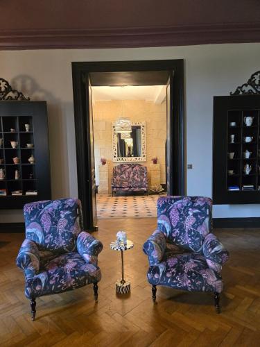 two chairs and a table in a room with a mirror at Château de Courtebotte in Saint-Jean-de-Blaignac