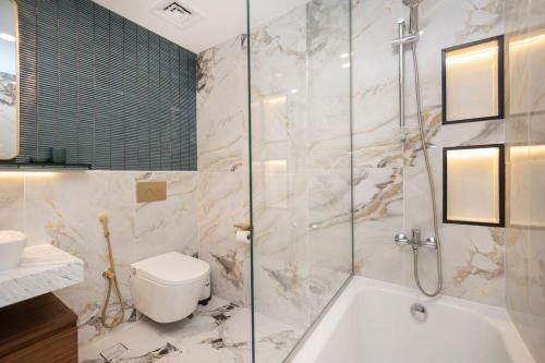a bathroom with a shower and a toilet and a sink at Luxurious 3BR APT Offering Full Burj AlArab Views in Dubai