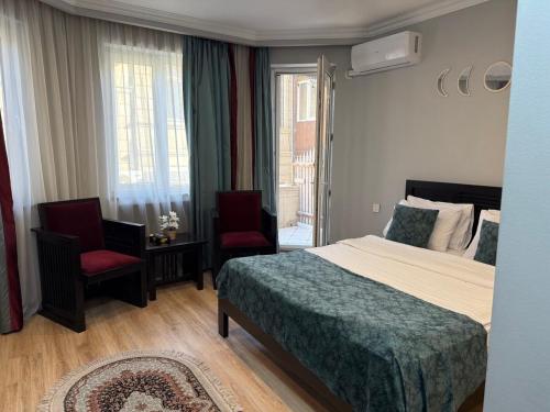 a hotel room with a bed and two chairs at Haz Boutique Hotel Baku in Baku
