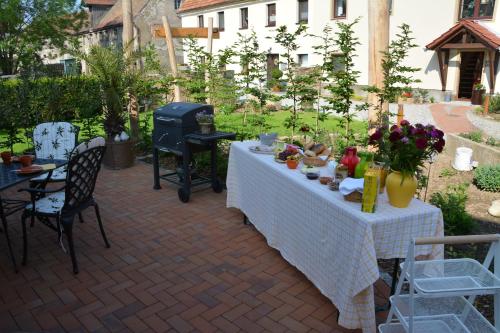 a patio with a table and chairs and a grill at Ferienappartements "Landromantik" in Bautzen