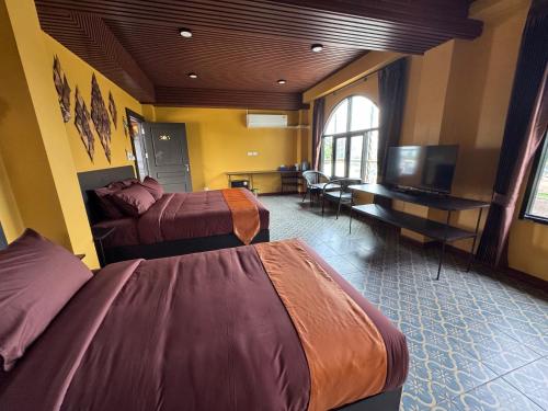 a hotel room with two beds and a flat screen tv at Phoenix Room in Ban Tha Samet (1)