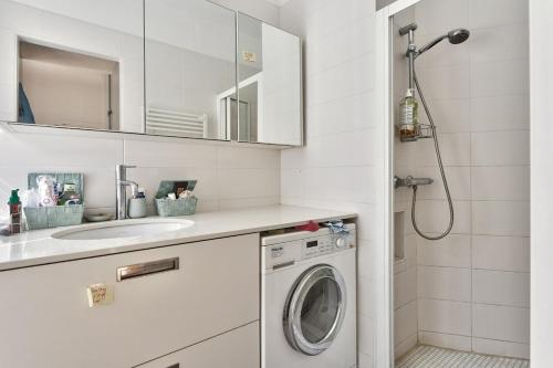 a bathroom with a washing machine and a sink at Spacieux et lumineux appartement in Paris