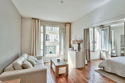 a white living room with a couch and a bed at Spacieux et lumineux appartement in Paris